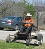Kirk operating a zero turn mower in the visitor center complex. 