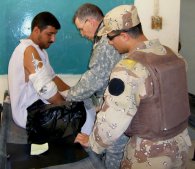 An American doctor treats an Iraqi civilian with a broken arm.