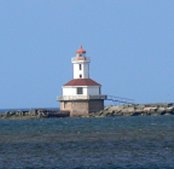 This lighthouse is perched on a rocky point, far from land at high tide.