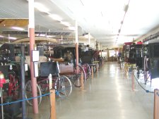 There is a room full of different buggies and carriages.