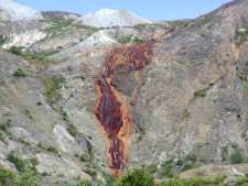 A waterfall that has streaked the rocks red with iron from a large ash pile that was partially refined by the heat of the eruption. The water picks up iron as it soaks through the cinders.